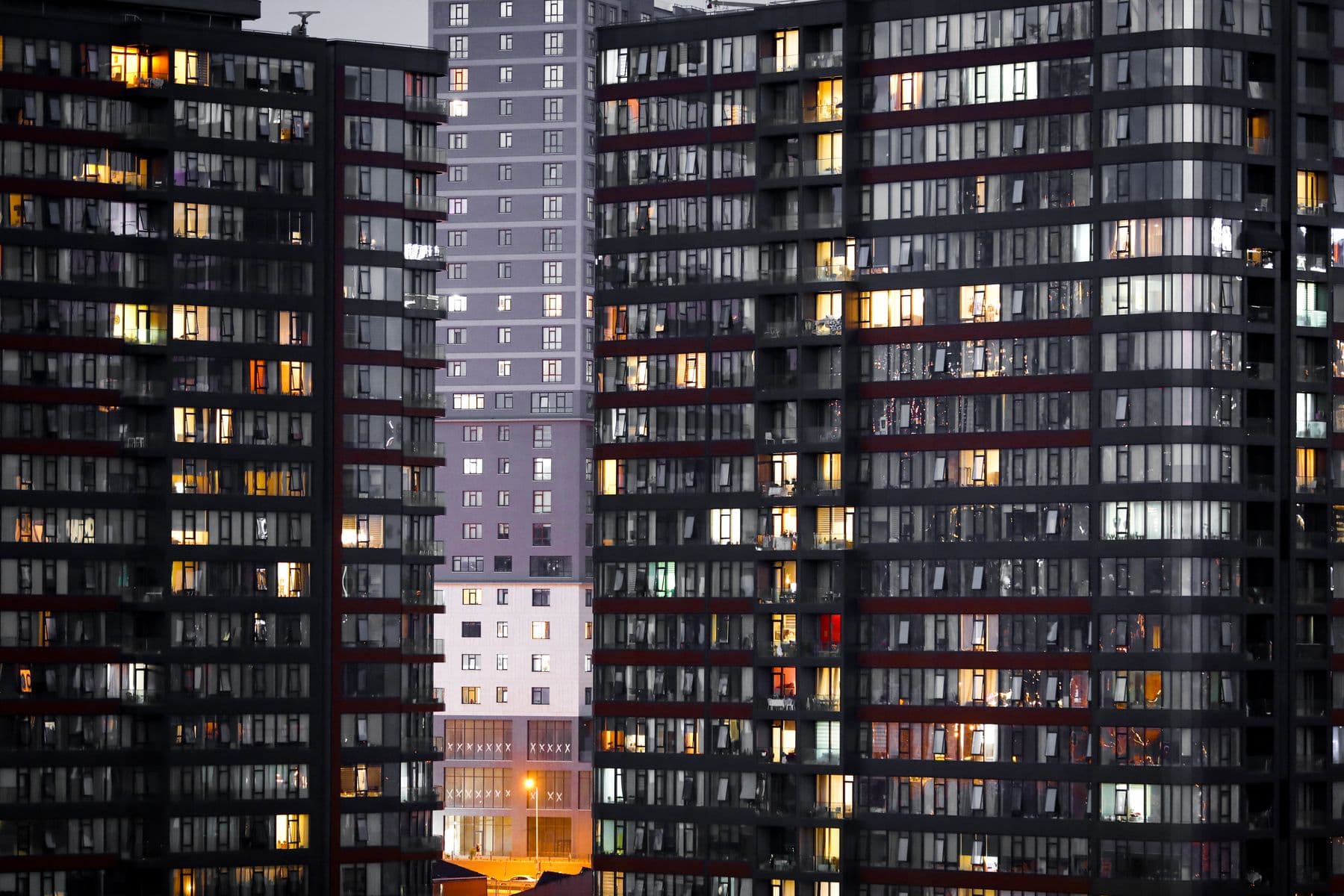 Dense residential condo towers at dusk with lit windows